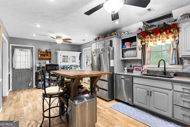 kitchen with visible vents, a sink, gray cabinetry, ceiling fan, and stainless steel appliances