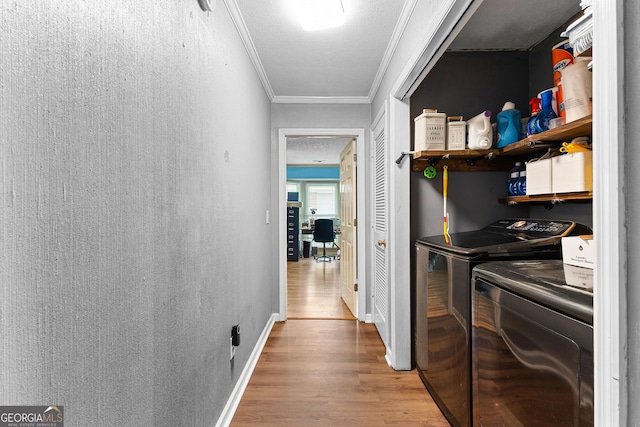 hallway with crown molding, baseboards, washer and clothes dryer, wood finished floors, and a textured ceiling