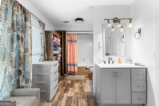 bathroom with wood finish floors, visible vents, toilet, curtained shower, and vanity