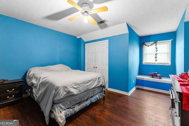 bedroom featuring visible vents, a ceiling fan, wood finished floors, a closet, and baseboards