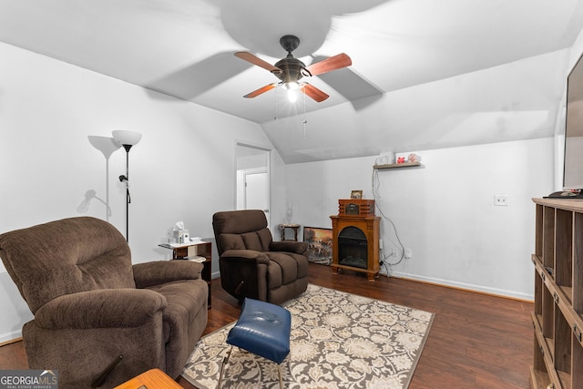 living area featuring lofted ceiling, a ceiling fan, wood finished floors, a fireplace, and baseboards