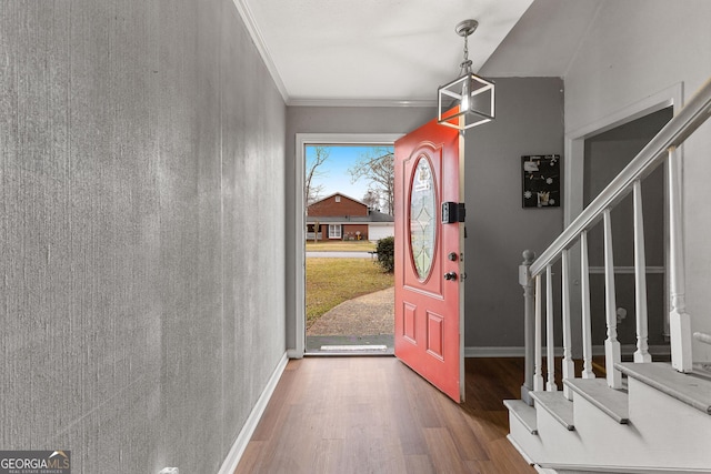 foyer with ornamental molding, stairs, baseboards, and wood finished floors