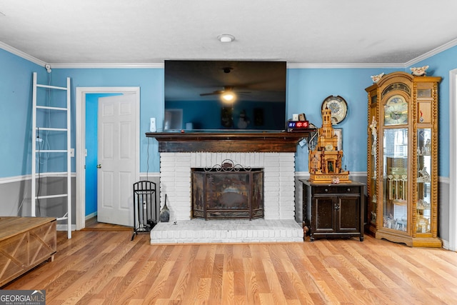 unfurnished living room with wood finished floors, a ceiling fan, ornamental molding, and a fireplace