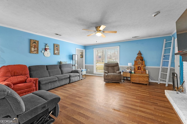 living room featuring visible vents, crown molding, ceiling fan, and wood finished floors