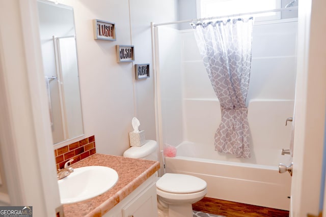 bathroom with tasteful backsplash, toilet, shower / tub combo, wood finished floors, and vanity