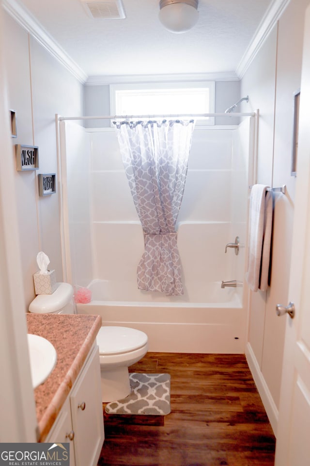 bathroom with visible vents, crown molding, toilet, shower / tub combo with curtain, and wood finished floors