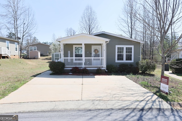 view of front of property featuring an outbuilding, a porch, a storage unit, and a front yard