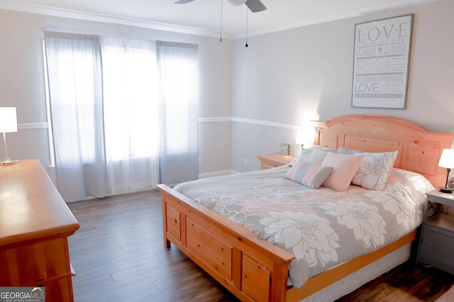 bedroom featuring ceiling fan, multiple windows, wood finished floors, and crown molding