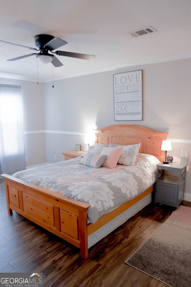 bedroom with visible vents, a ceiling fan, dark wood-style floors, and crown molding