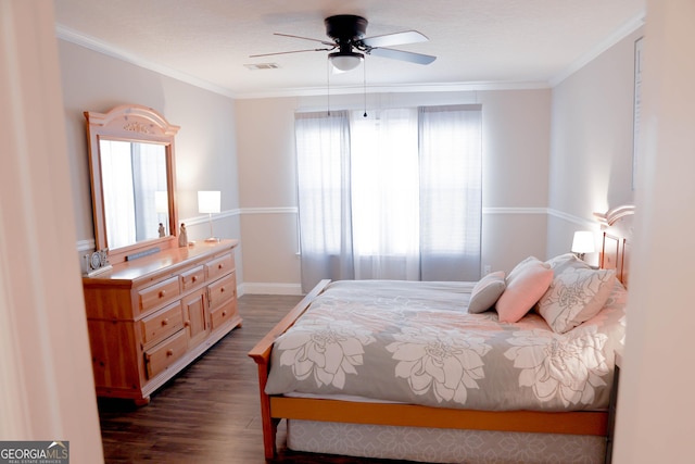 bedroom featuring dark wood finished floors, visible vents, crown molding, and a ceiling fan