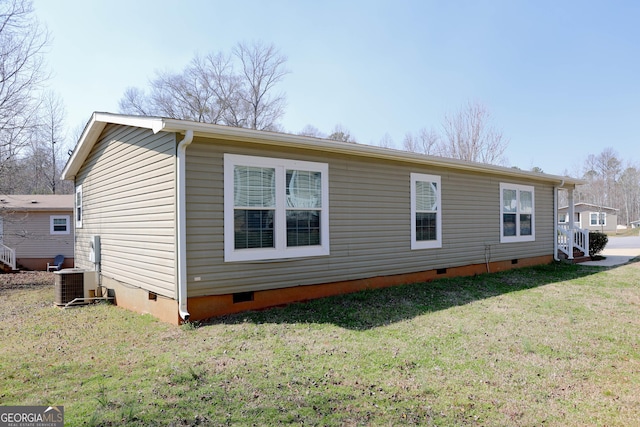 rear view of property featuring crawl space, central air condition unit, and a lawn