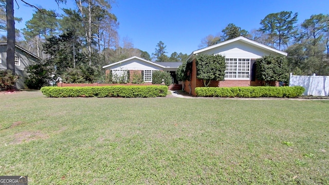 single story home with brick siding, a front yard, and fence