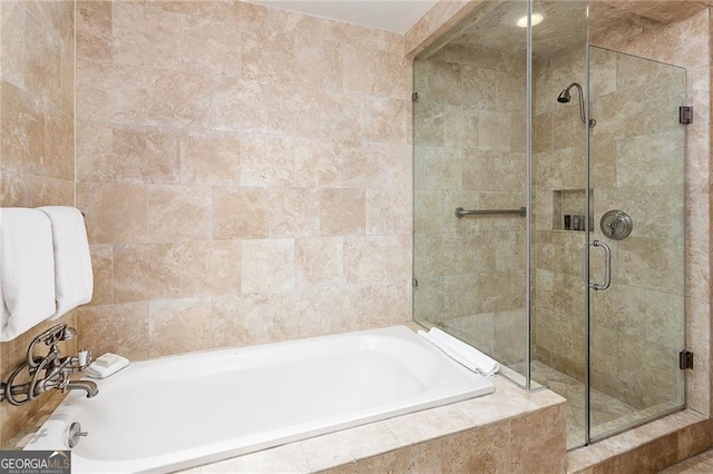 full bath featuring tile walls, a bath, and a shower stall