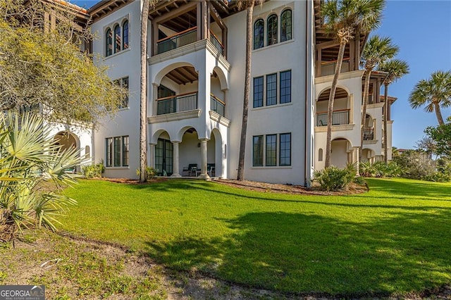 view of front of home with stucco siding and a front lawn