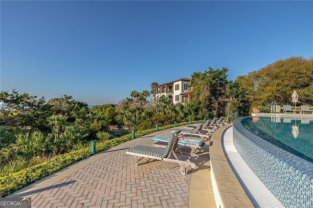 view of property's community featuring a pool and a patio