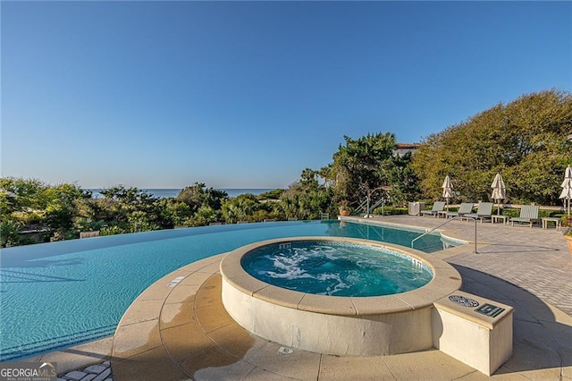 view of pool with a patio and a hot tub