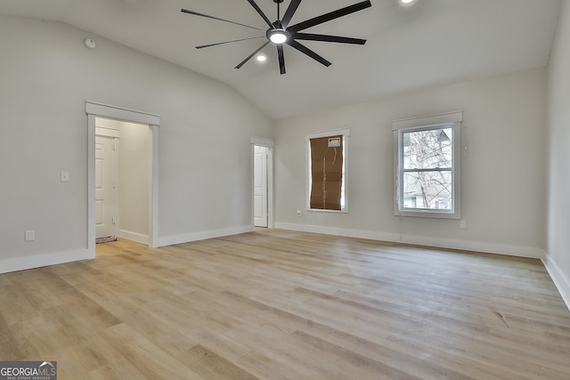 spare room featuring vaulted ceiling, light wood-style floors, baseboards, and ceiling fan