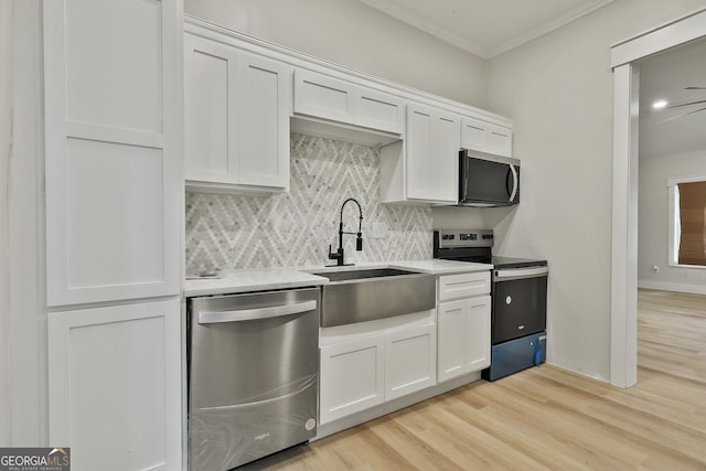 kitchen with white cabinetry, tasteful backsplash, appliances with stainless steel finishes, and a sink