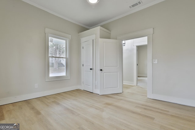 unfurnished bedroom with crown molding, baseboards, visible vents, and light wood-type flooring