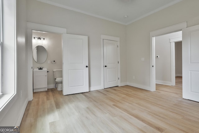 unfurnished bedroom featuring light wood finished floors, a sink, baseboards, and ornamental molding