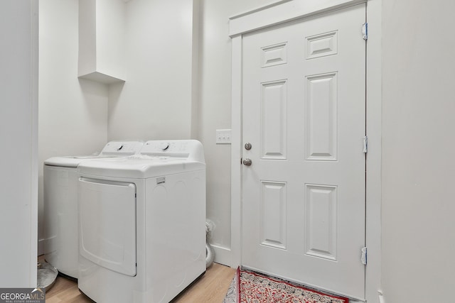 washroom with light wood-type flooring, laundry area, and washing machine and clothes dryer