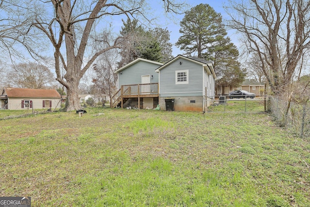 rear view of property with fence, a deck, a lawn, and a gate