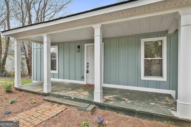 view of exterior entry featuring a porch and board and batten siding