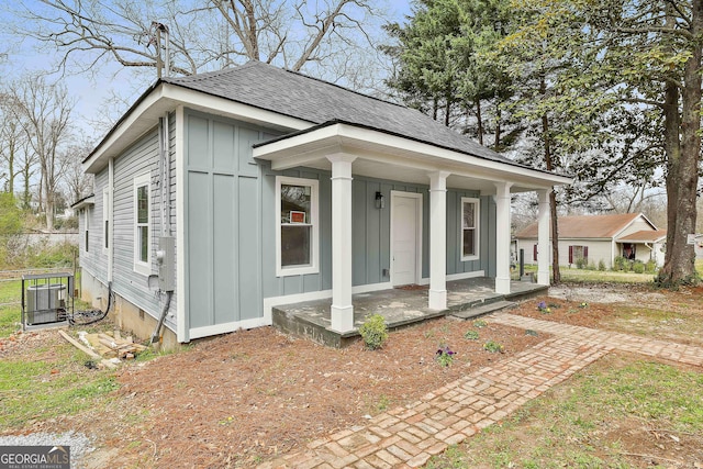 view of front of property with a porch, board and batten siding, and roof with shingles