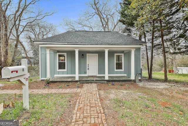 bungalow-style home featuring a porch, roof with shingles, and board and batten siding