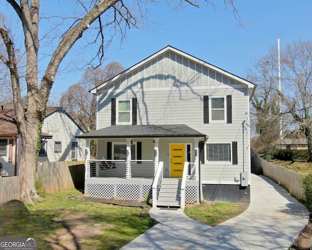 view of front of home with a porch, fence, board and batten siding, and driveway