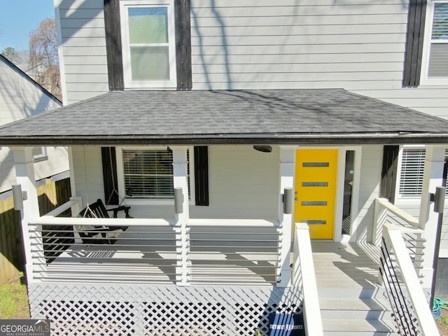 entrance to property with fence and roof with shingles