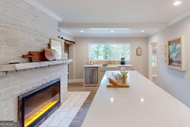 kitchen with dishwasher, a fireplace, crown molding, and light wood finished floors