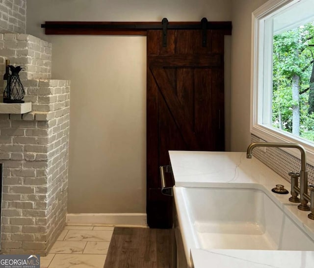laundry area featuring laundry area, a healthy amount of sunlight, marble finish floor, and a sink