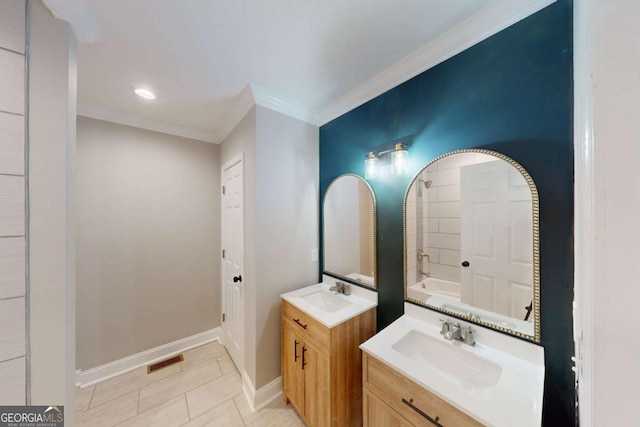 bathroom featuring a sink, visible vents, baseboards, and ornamental molding