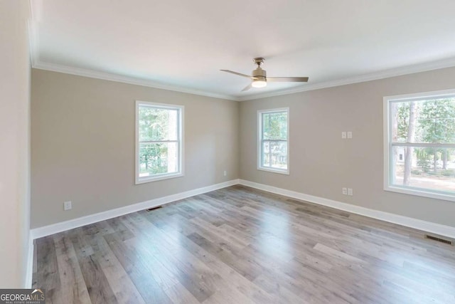 empty room with a healthy amount of sunlight, baseboards, ceiling fan, and wood finished floors