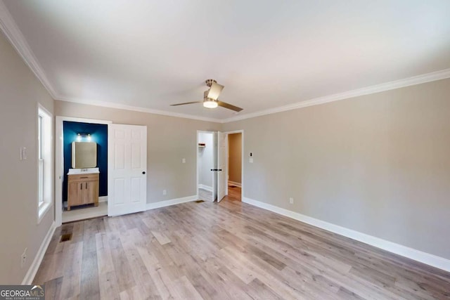 unfurnished bedroom with ornamental molding, a ceiling fan, connected bathroom, light wood-style floors, and baseboards