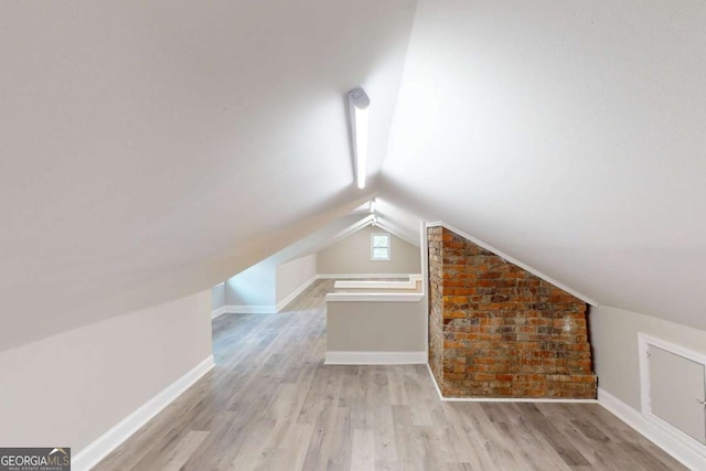 bonus room with lofted ceiling, wood finished floors, and baseboards