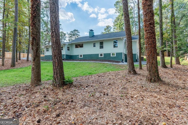 back of property with a yard and a chimney