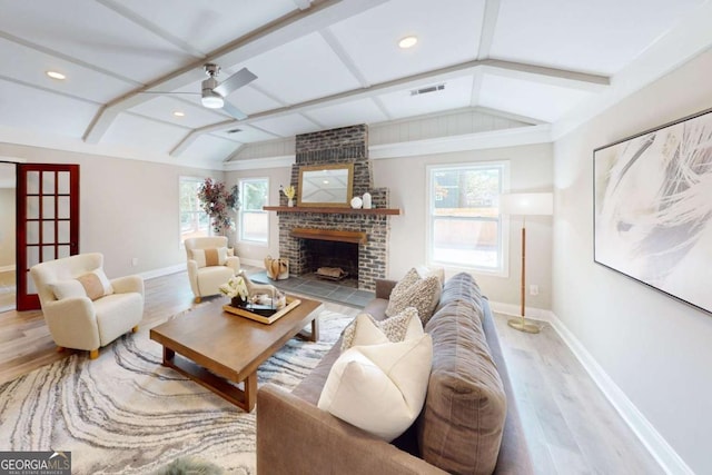 living room with wood finished floors, baseboards, visible vents, vaulted ceiling with beams, and ceiling fan