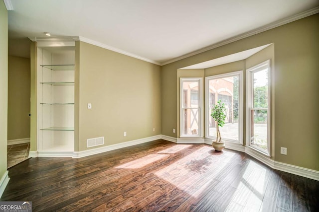 empty room featuring visible vents, ornamental molding, baseboards, and dark wood-style flooring