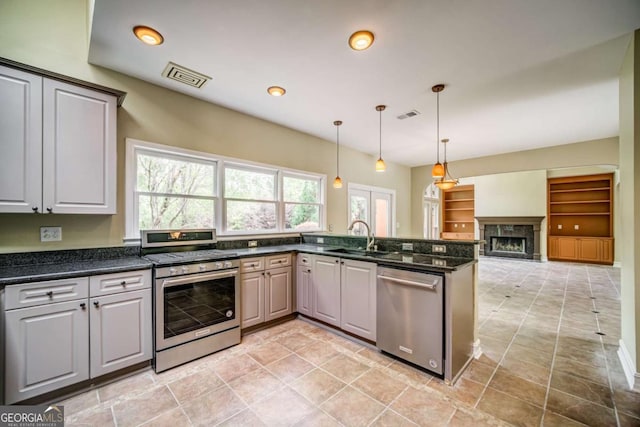 kitchen with open floor plan, visible vents, appliances with stainless steel finishes, and a sink