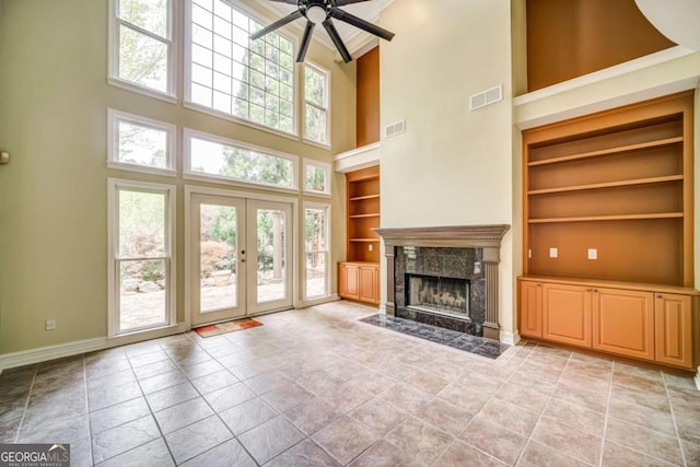 unfurnished living room featuring visible vents, built in shelves, and plenty of natural light