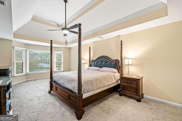 carpeted bedroom with a ceiling fan, a raised ceiling, visible vents, and baseboards