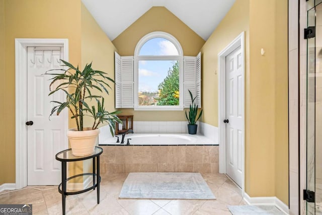 full bath featuring tile patterned flooring, vaulted ceiling, and a bath