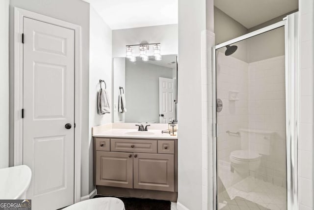 bathroom with toilet, a stall shower, and vanity