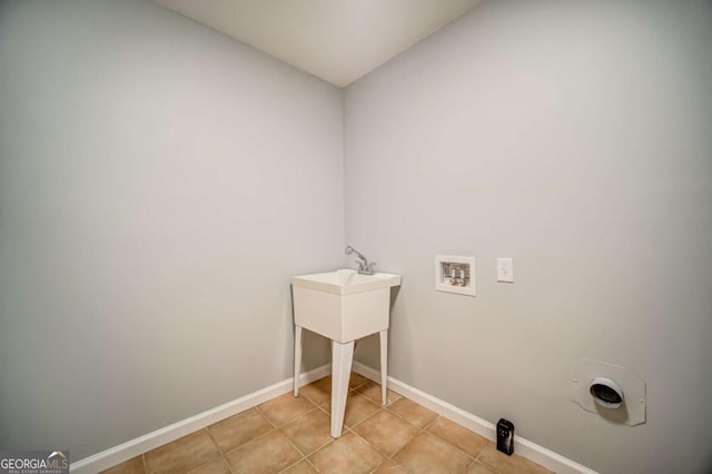 laundry area with light tile patterned floors, laundry area, baseboards, and washer hookup