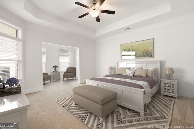 bedroom with a tray ceiling, baseboards, visible vents, and carpet flooring