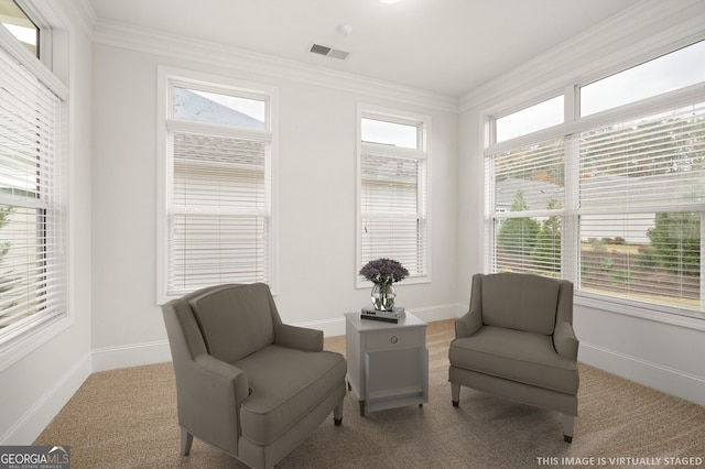 sitting room with visible vents, baseboards, and ornamental molding