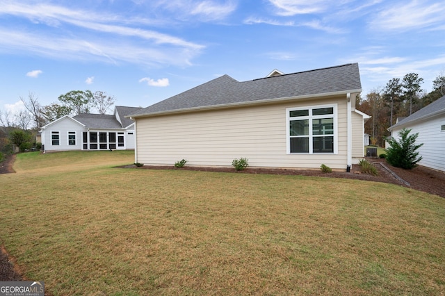 view of property exterior with a lawn and roof with shingles