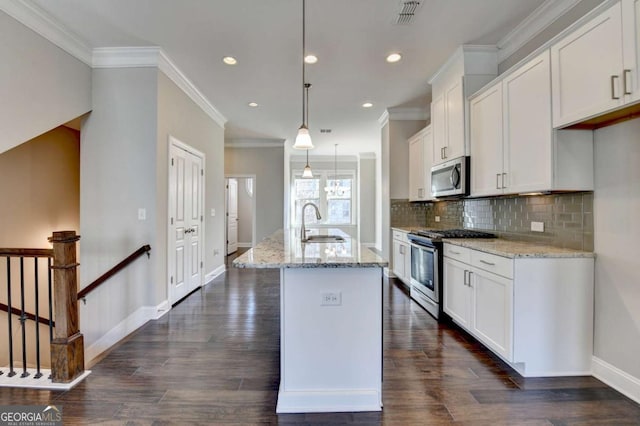 kitchen with visible vents, a kitchen island with sink, a sink, stainless steel appliances, and white cabinets